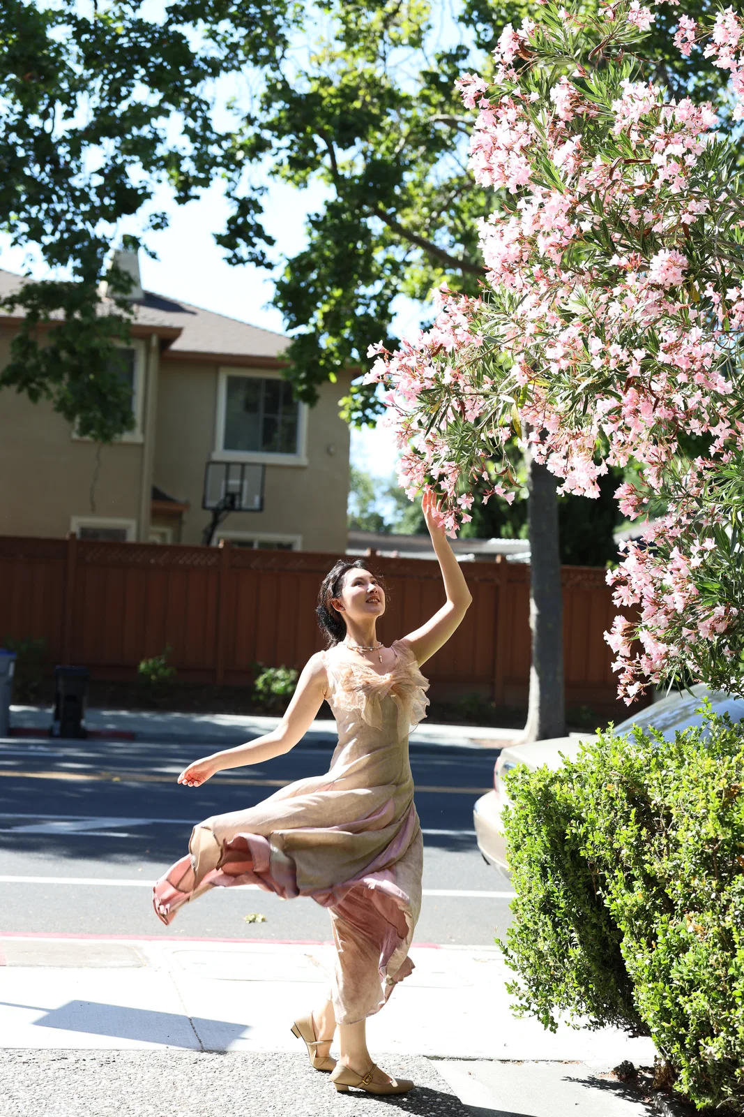 A woman dancing beneath a flowering tree
